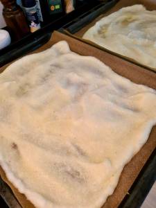 En platt omelettwrap som ligger på ett bakplåtspapper i en ugnsform.