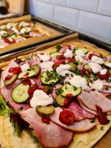 Omelettwrap fylld med skinka, gurka, tomater och gräddfil på en plåt.