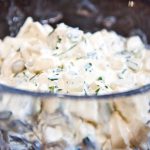 En skål med rättikasallad som innehåller bitar av rättika och en krämig dressing.