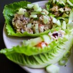 Salladsblad fyllda med tonfiskröra och hackade grönsaker på en tallrik.