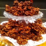 En hög med chokladkrisp i olika former på ett glas tårtfat.