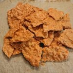 En hög med kycklingchips som ligger på bakplåtspapper.