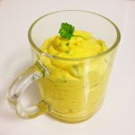 Currymajonnäs med grönsaksbitar i en genomskinlig glasbehållare med handtag.