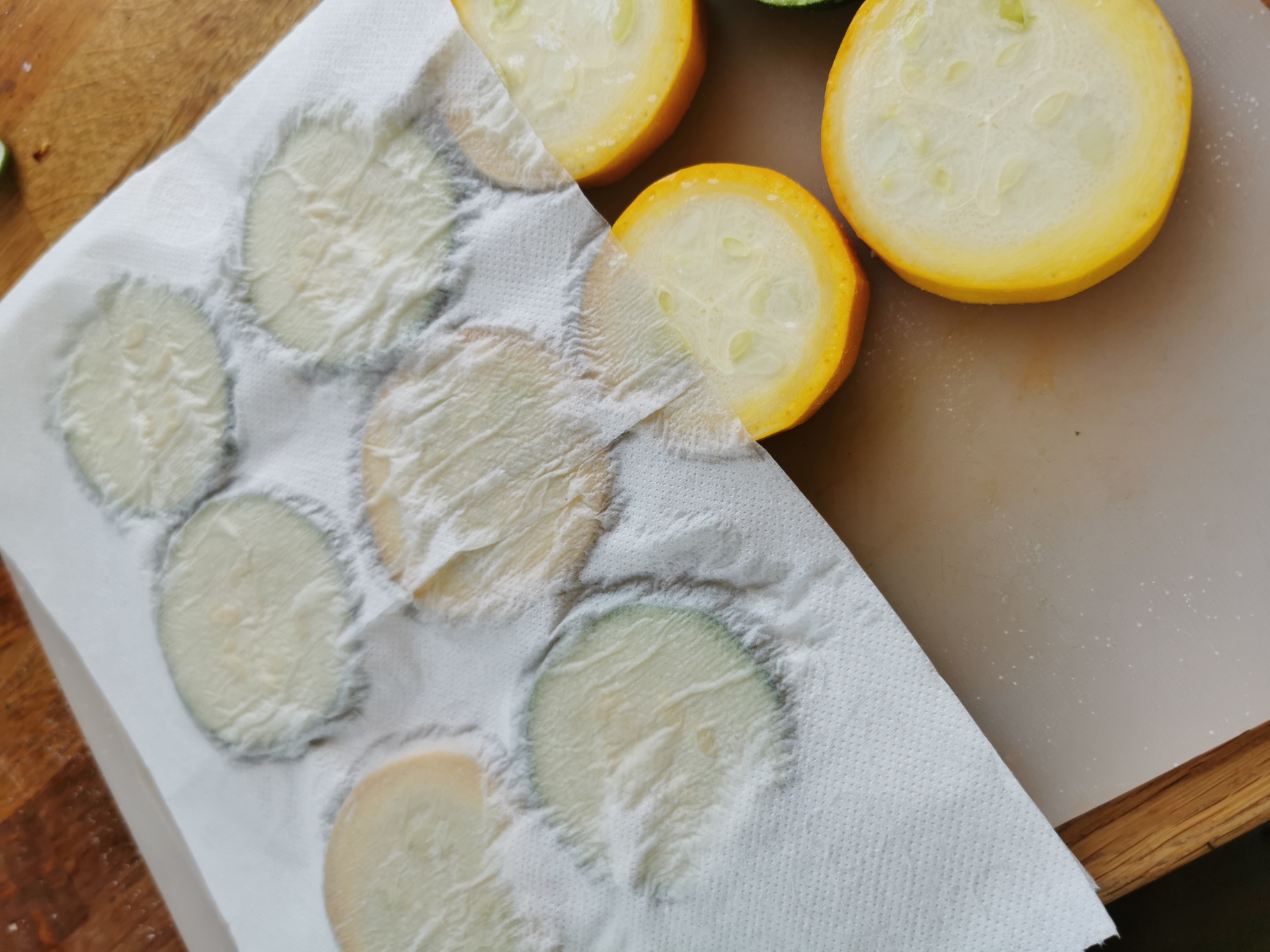 Skivor av citron och zucchini placerade på en pappershandduk för att absorbera fukt.