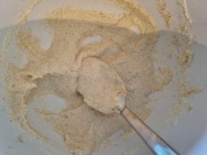 En skål med en blandning av ingredienser som rörs om med en sked.