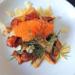 En tallrik med svamp, fiskrom och dill på en vit bakgrund.