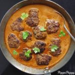 Köttbullar i en gräddig sås med färska örter i en stekpanna.