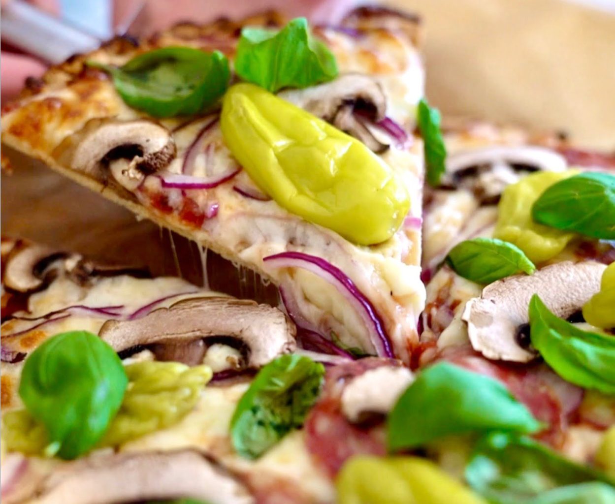 Pizza - Blomkålsbotten 7 En skiva pizza med svamp, lök, basilika och gröna paprikor på toppen.