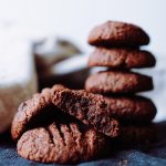 En hög av chokladkakor med en krossad kaka i förgrunden som visar den inre texturen.