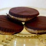 Tre chokladkakor med nötfyllning på en glasfat.