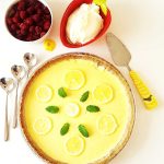 Citronpaj dekorerad med citronskivor och mynta på en vit yta.