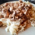 En tallrik med köttgryta serverad på potatismos, med en krämig sås och bitar av kött.